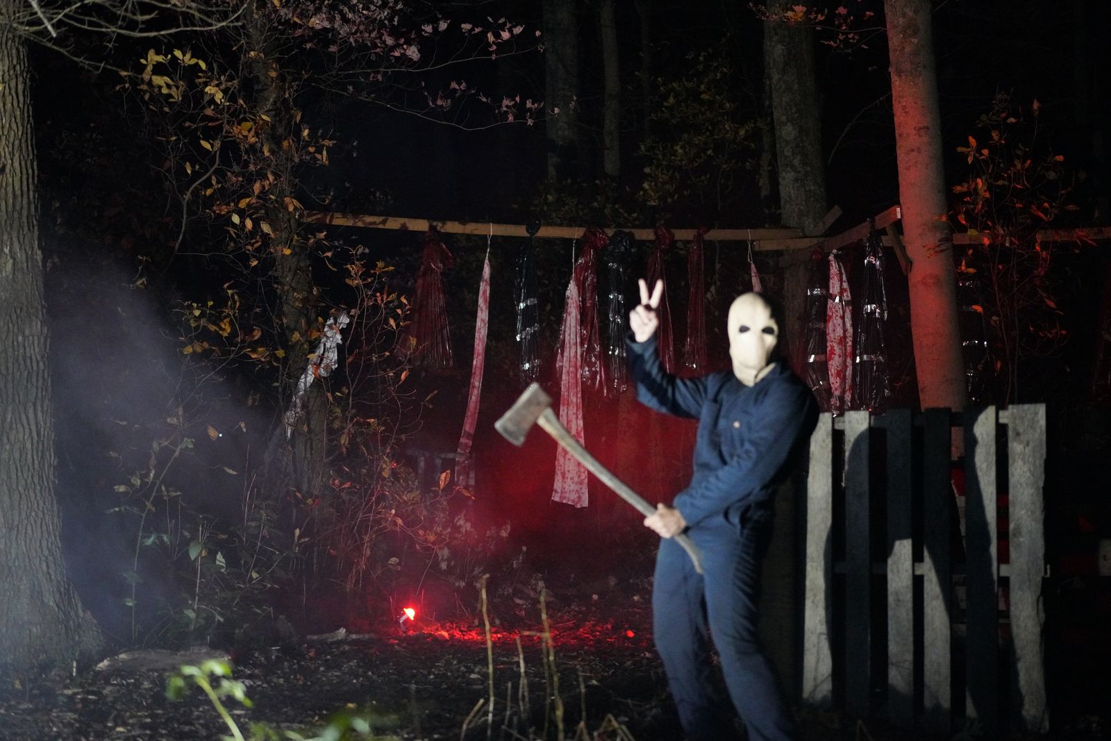 A masked figure with an axe in red light